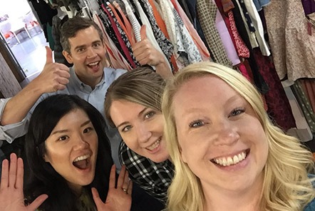A group of people posing for a photo in a clothing store.